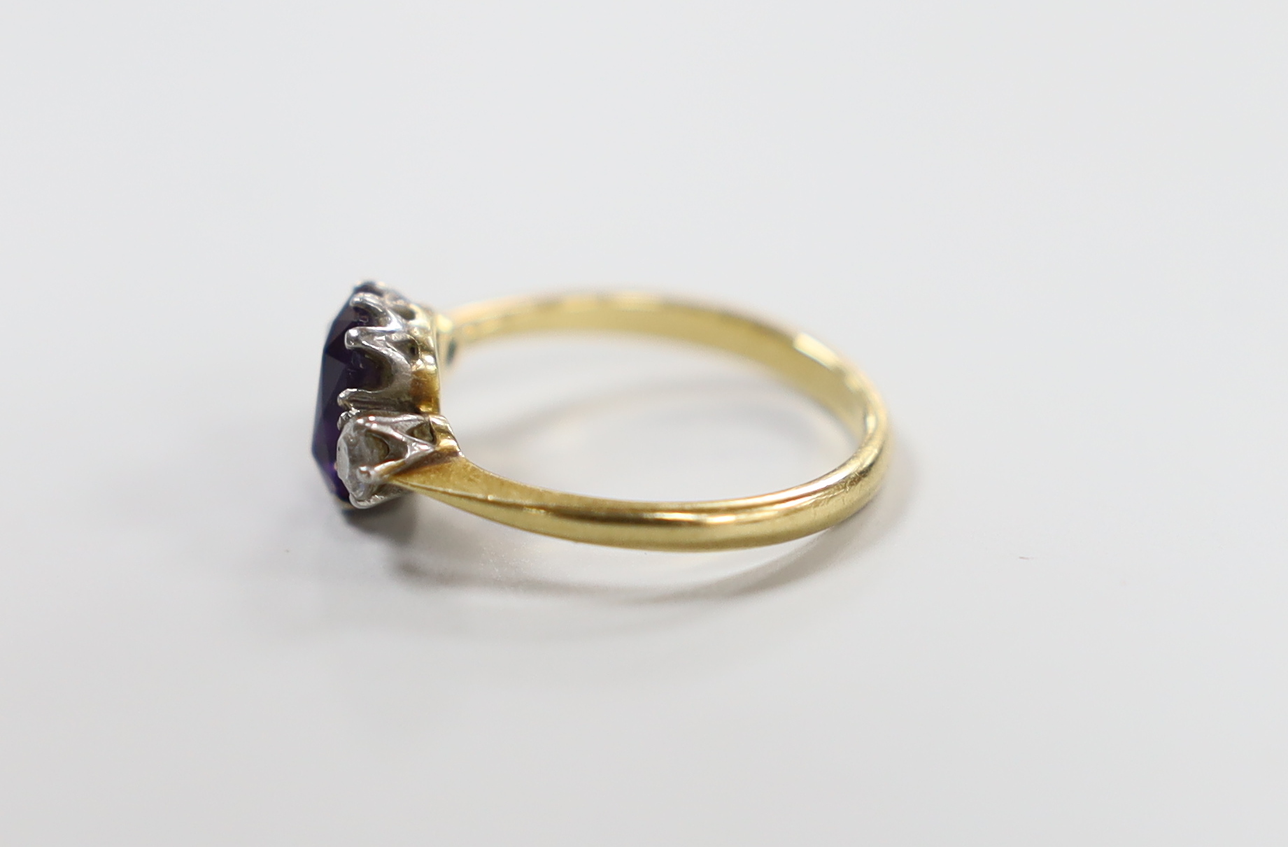 An 18ct, single stone amethyst and two stone diamond set ring, size N, gross weight 3 grams.